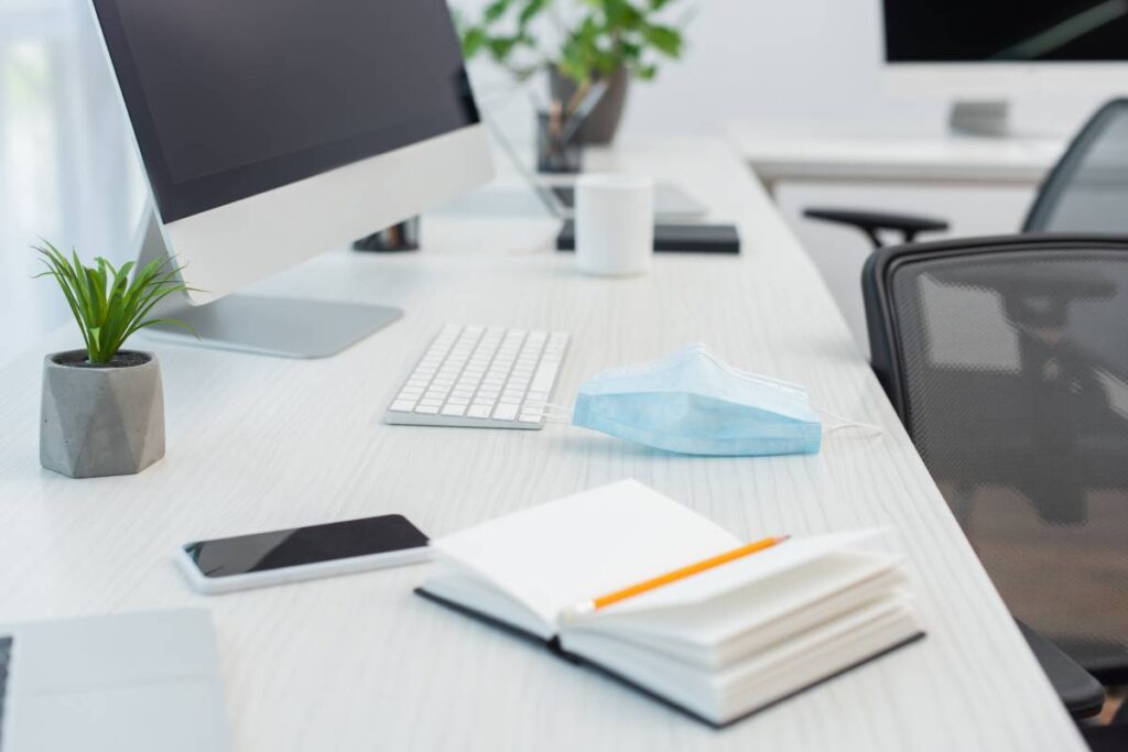 notebook and medical mask near smartphone with blank screen, keyboard and computer monitor aviod frame Fire Safety
