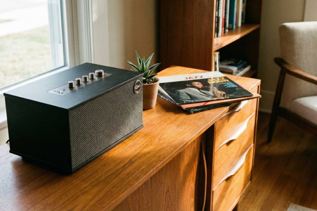 A Klipsch The Three II sitting on a teak